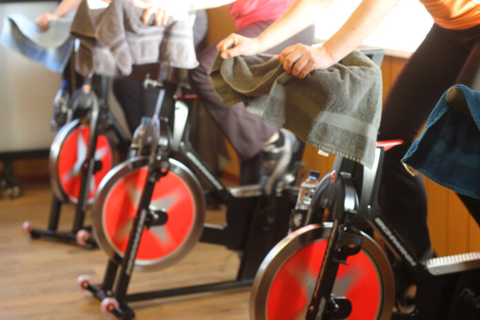 Mujeres toman clase de spinning con música de banda en vivo